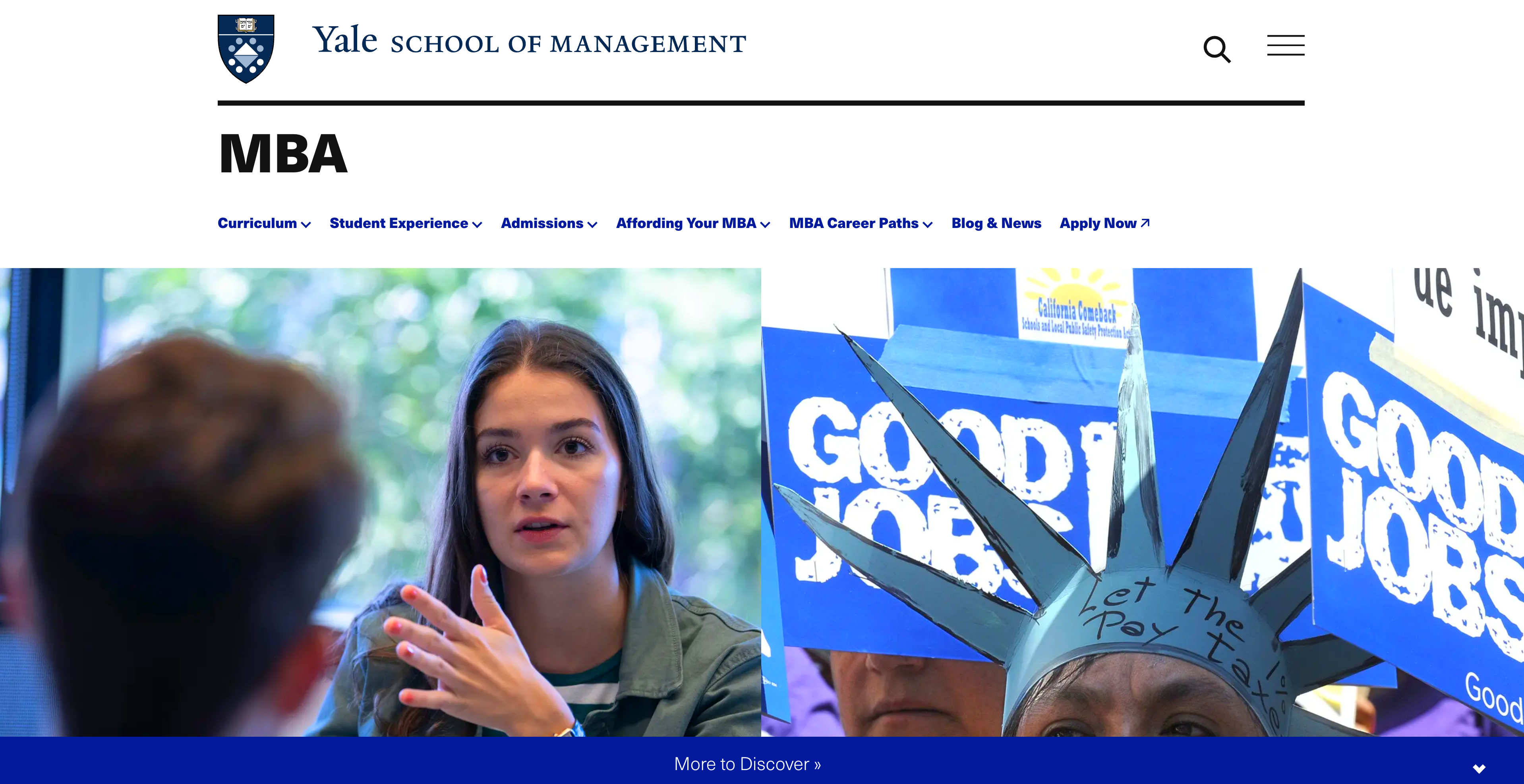 Person gesturing while speaking at an MBA event with branded banners in background.