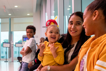 Mother holding young children in colorful clothing in a pediatric waiting room