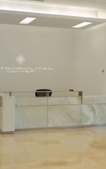 Modern reception desk with marble front in a minimalist white interior space.