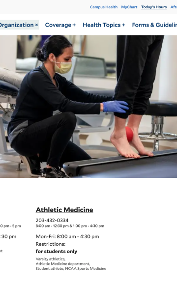 Person working on computer equipment at a desk in what appears to be a university setting.