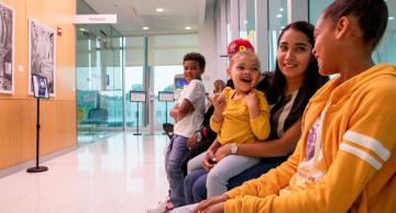 A family in orange shirts sitting in a waiting room area of a medical facility.